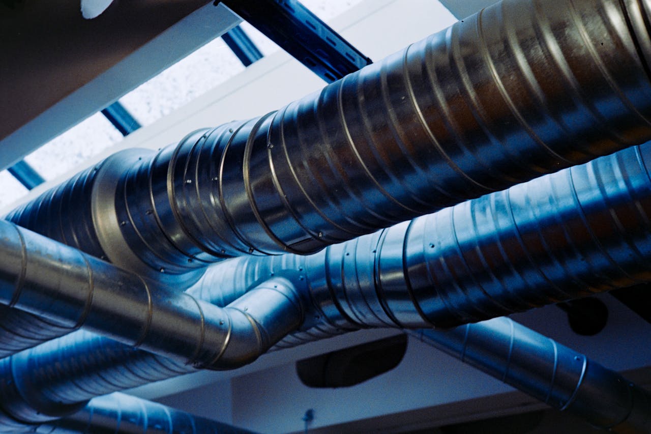 our-services-02 Close-up of a modern metallic ventilation system in an industrial setting.